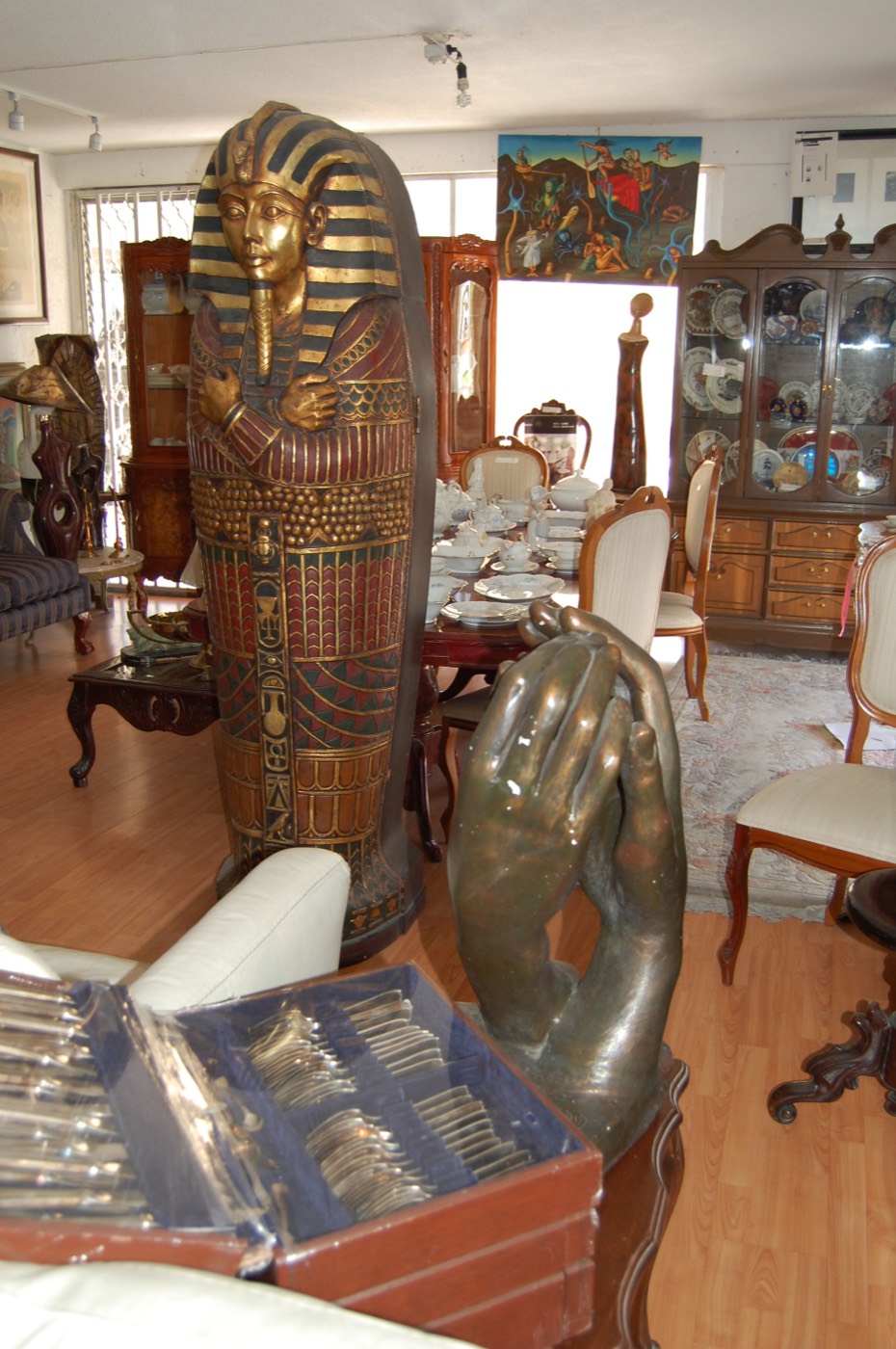 Antigüedades y objetos de colección en exhibición, incluyendo un sarcófago decorativo y muebles de época en Tesoros Bazar