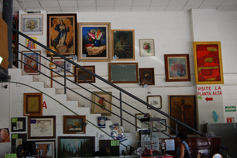 Pared de escalera cubierta de cuadros en Tesoros Bazar